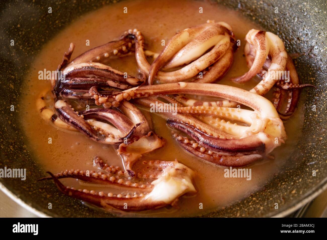 preparing stewed squid tentacles with tomato sauce Stock Photo - Alamy