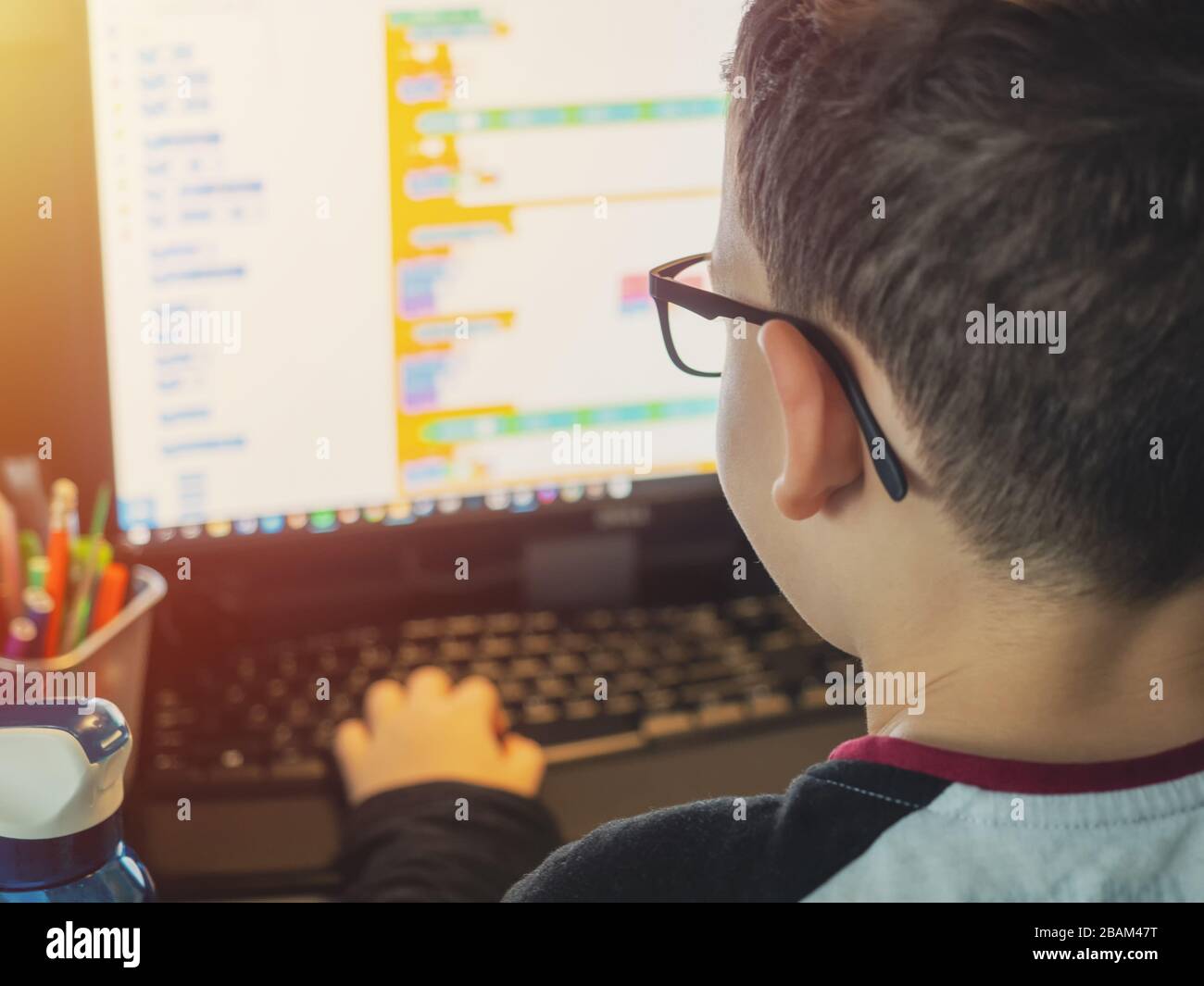 Smart young boy works on a PC for his new project in his computer science class Stock Photo