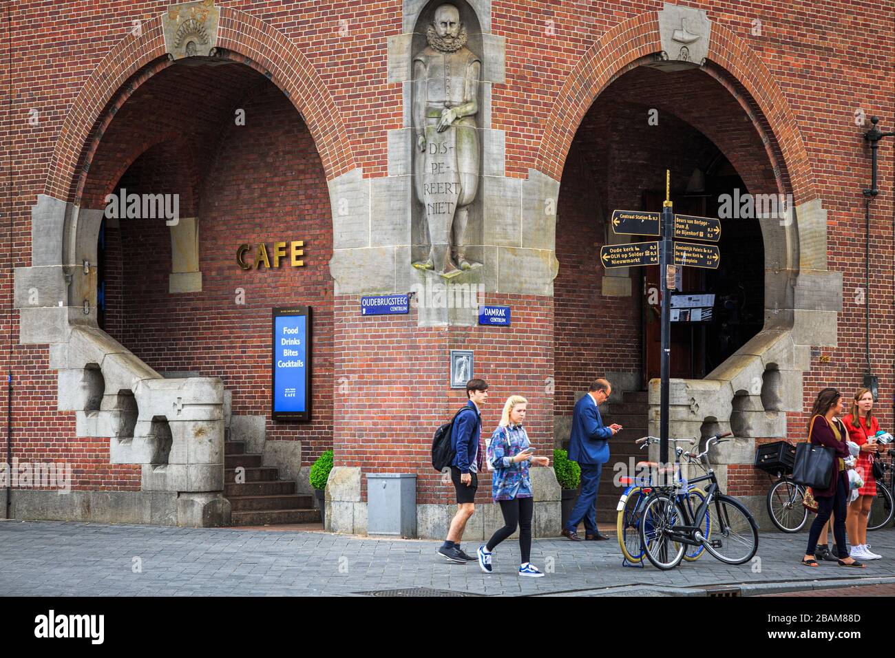 The New York Film Academy Café entrance, located between Oudebrugsteeg and Damrak, with tourists and bicycles. Stock Photo