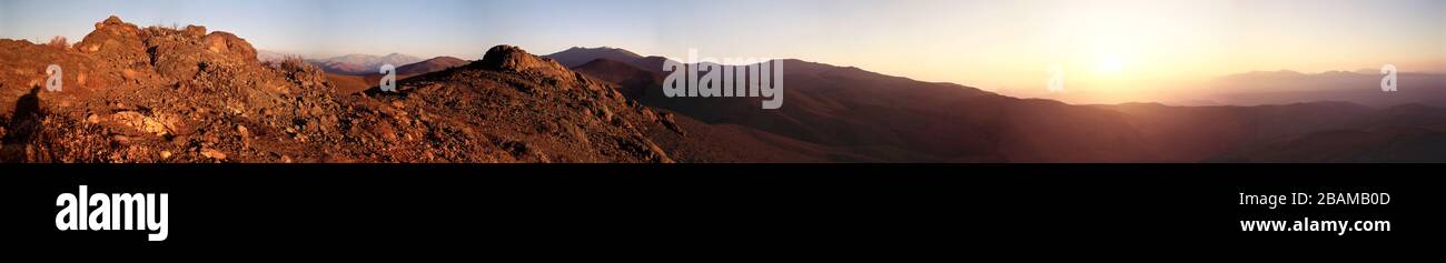 'English: This unique panoramic view of the La Silla area stretches across an angle of nearly 270° and was obtained by combining nine 6x9 cm exposures with a Linhof Technika camera. It was made at sunset from a point near the access road that descends to the Pelicano Camp at the entry to the ESO area. The 3.6-m telescope tower is at the left on the observatory ridge, the living quarters are to the far right of the site and many of the telescope domes are seen in between. Photograph and computer work by Hans Hermann Heyer (ESO). The La Silla Observatory is located in the Chilean Atacama Desert, Stock Photo