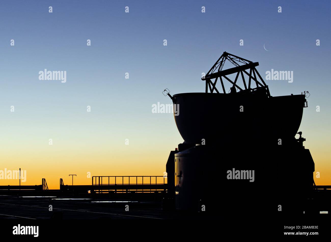 English: Pictured here at sunset is one of the four Auxiliary Telescopes  (ATs) of the Very Large Telescope Interferometer (VLTI), shown at ESO's  Paranal Observatory. The faint crescent Moon can be seen