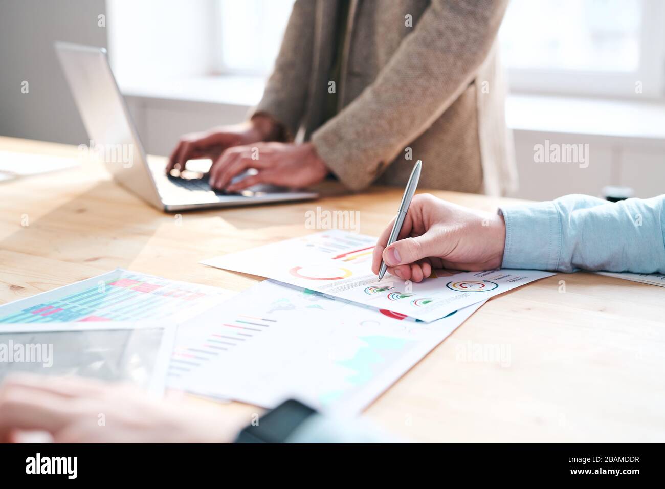 Close-up of unrecognizable financial expert making notes in chart while analyzing month report in office Stock Photo
