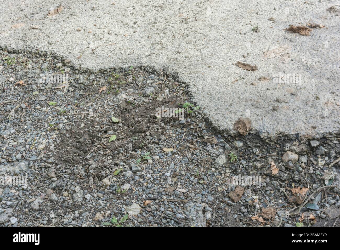 Crumbling tarmac edge failure of a neglected country road. Metaphor poor infrastructure, badly maintained, disintegration, rough roads, old tarmac. Stock Photo