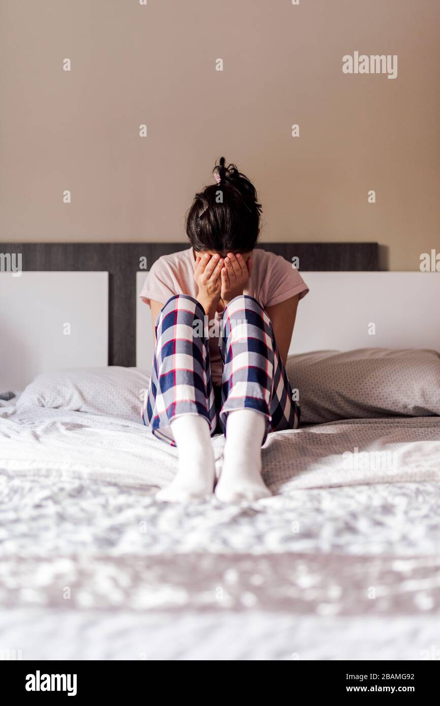 Girl crying in her room bed. Concept of dramatic loneliness, sadness, depression, sad. Stock Photo