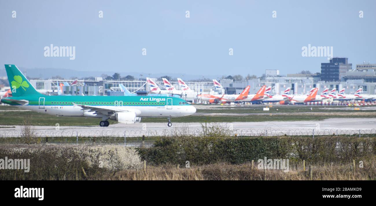 An Aer Lingus Airbus A320-214 moves towards take off at Gatwick Airport passing in front of many grounded British Airways and easyJet planes. Stock Photo