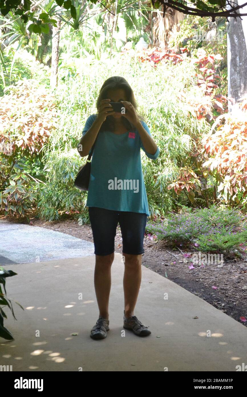 Lady photographer in a tropical garden Stock Photo