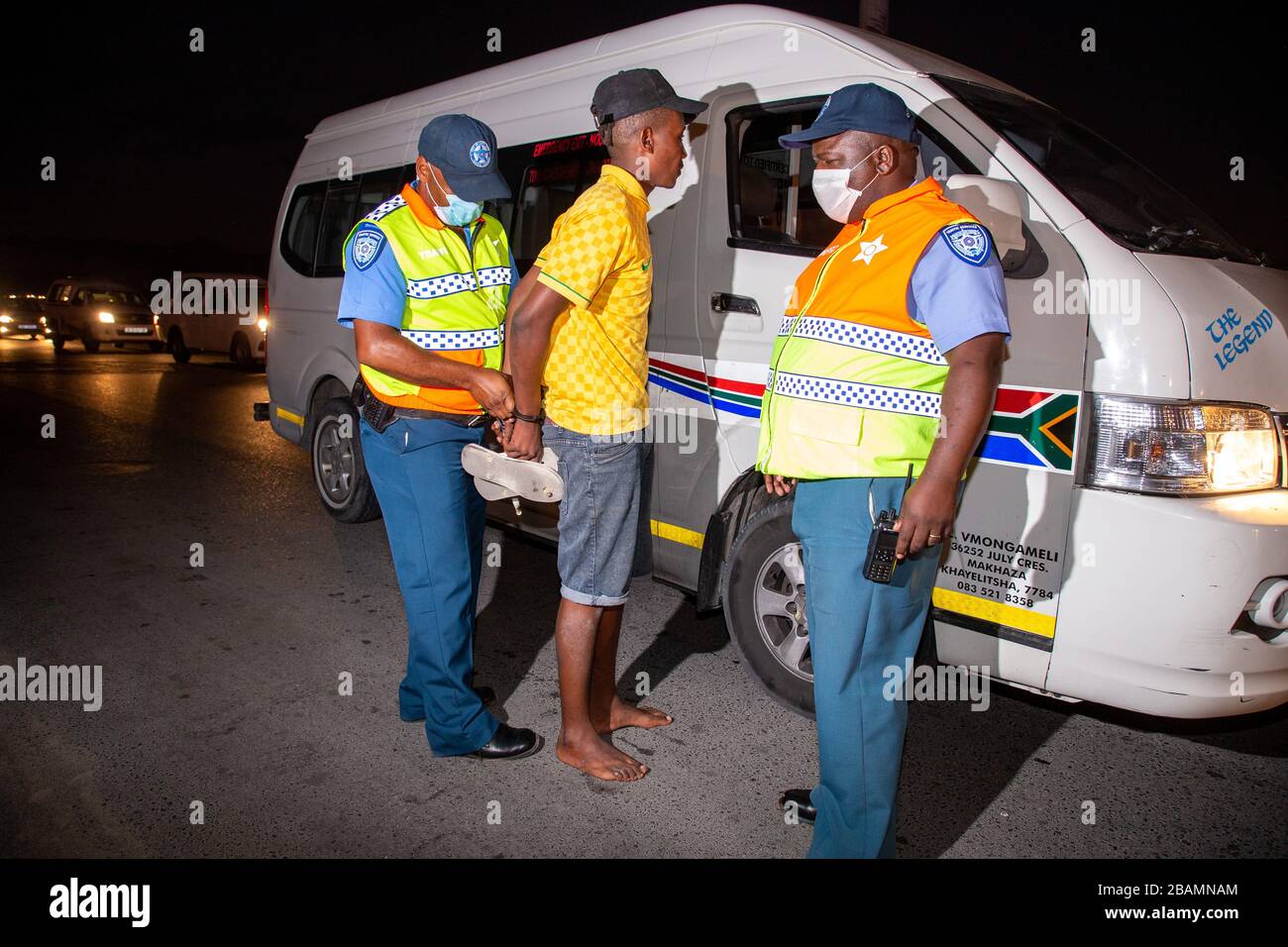 CAPE TOWN, SOUTH AFRICA - Saturday 28 March 2020: a taxi driver is arrested at a roadblock in Khayelitsha by traffic officers from the City of Cape Town after the South African government declared a 21 day COVID-19 lockdown as part of the State of National Disaster declaration by President Cyril Ramaphosa. The Health Ministry has asked residents to observe the regulations, practise hygiene, stay at home and practise social distancing. Photo by Roger Sedres Stock Photo