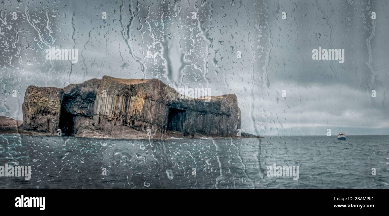 Staffa Island in Scotland through boat window covered in raindrops. Stock Photo