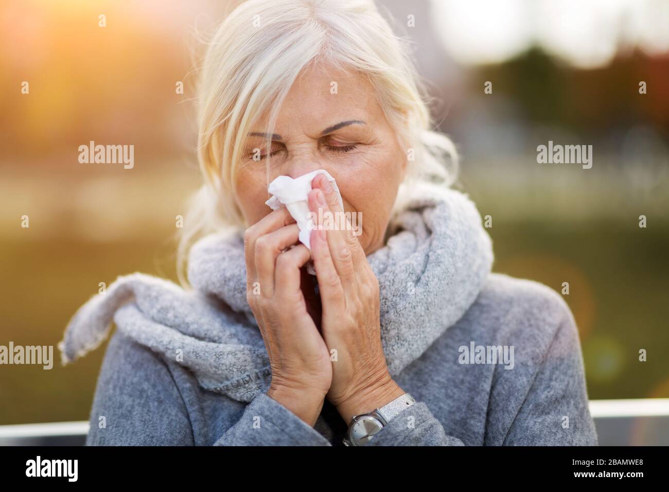 Senior woman with a tissue outdoors Stock Photo