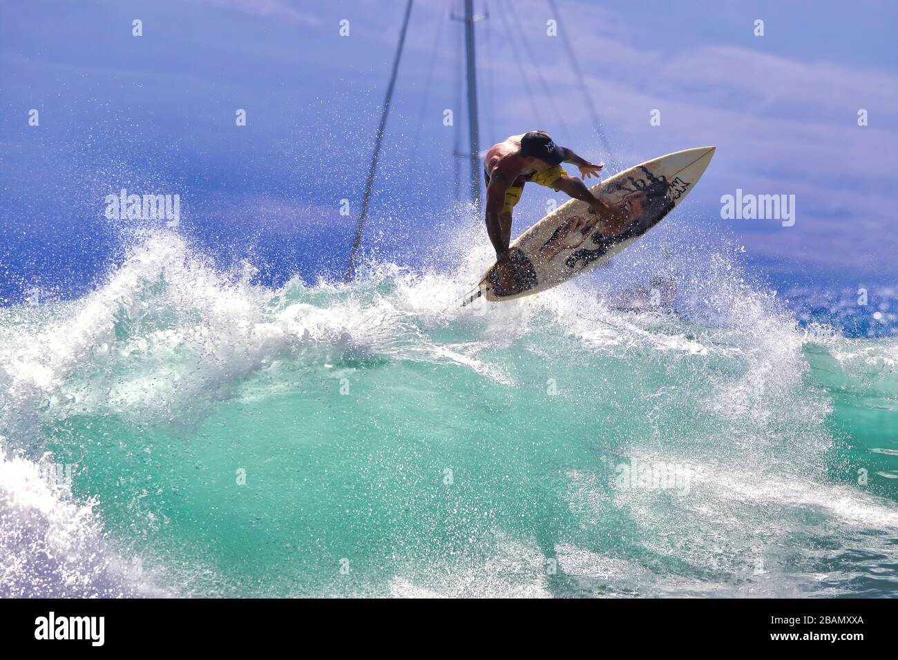High energym action of a young male surfer riding a turbulent wave. Stock Photo