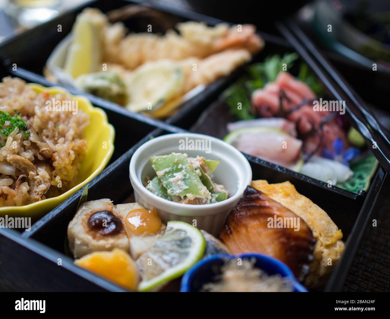 Japanese Bento box lunch with raw fish, rice, tempura and vegetables