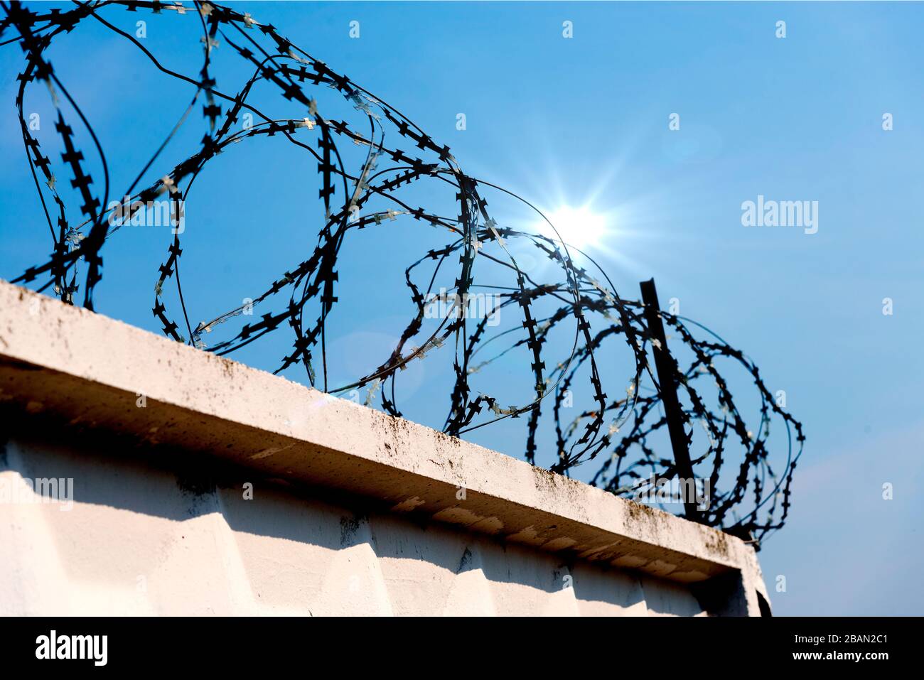 Barbed wire fence against the blue sky Stock Photo - Alamy