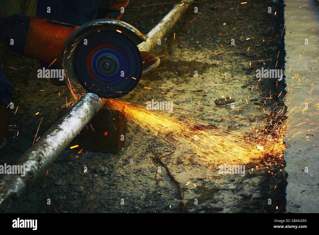 A angular grinding machine cutting a metal tube with a spurks bunch Stock Photo