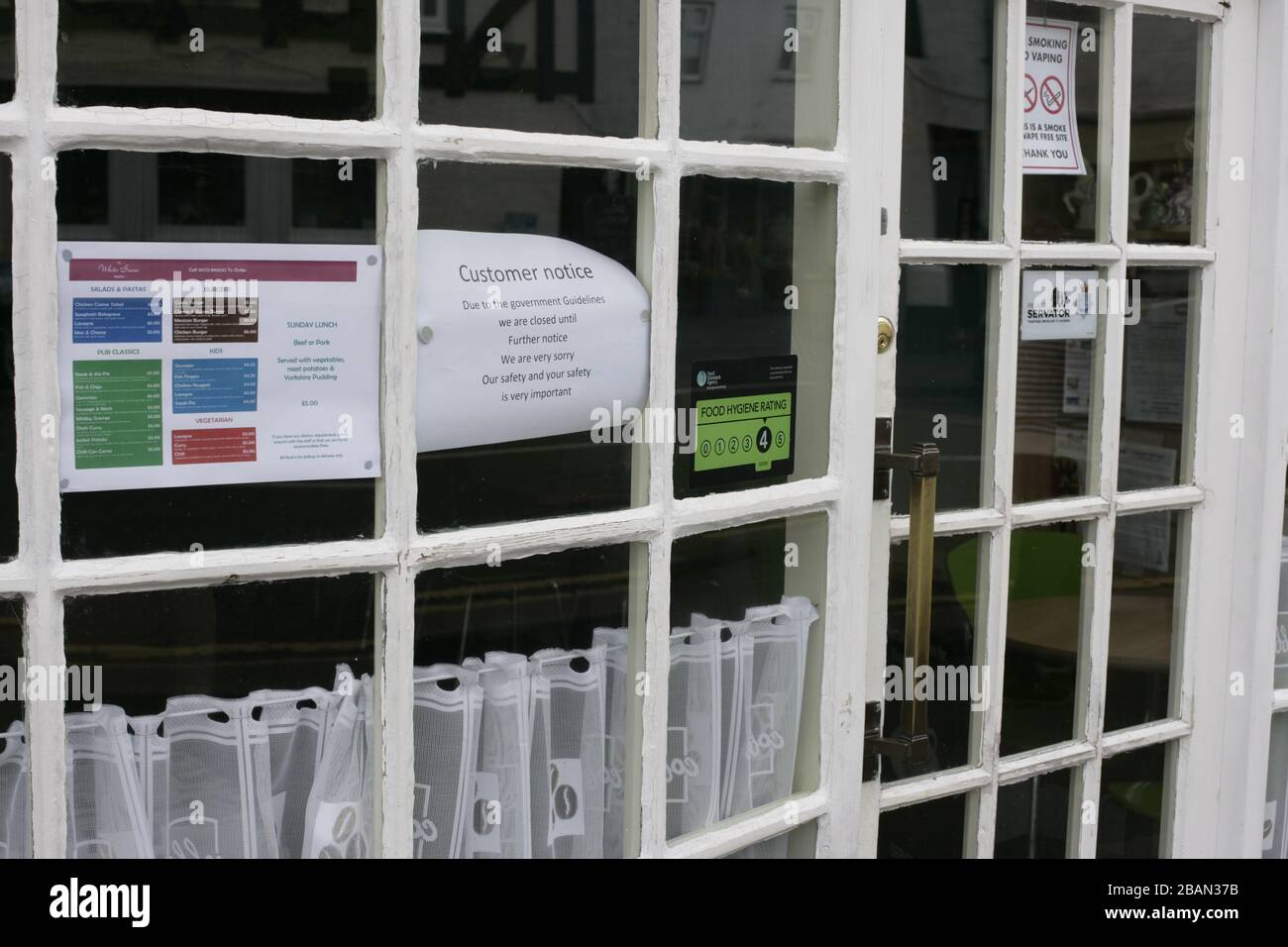 Customer notice shop closure sign on coffee shop door window during