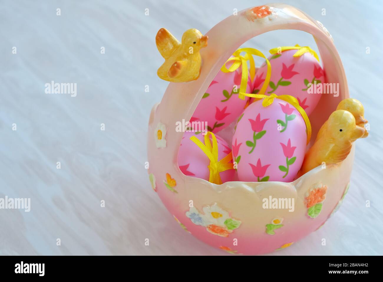 Easter ceramic basket with decorative pink eggs, festive home decor Stock Photo