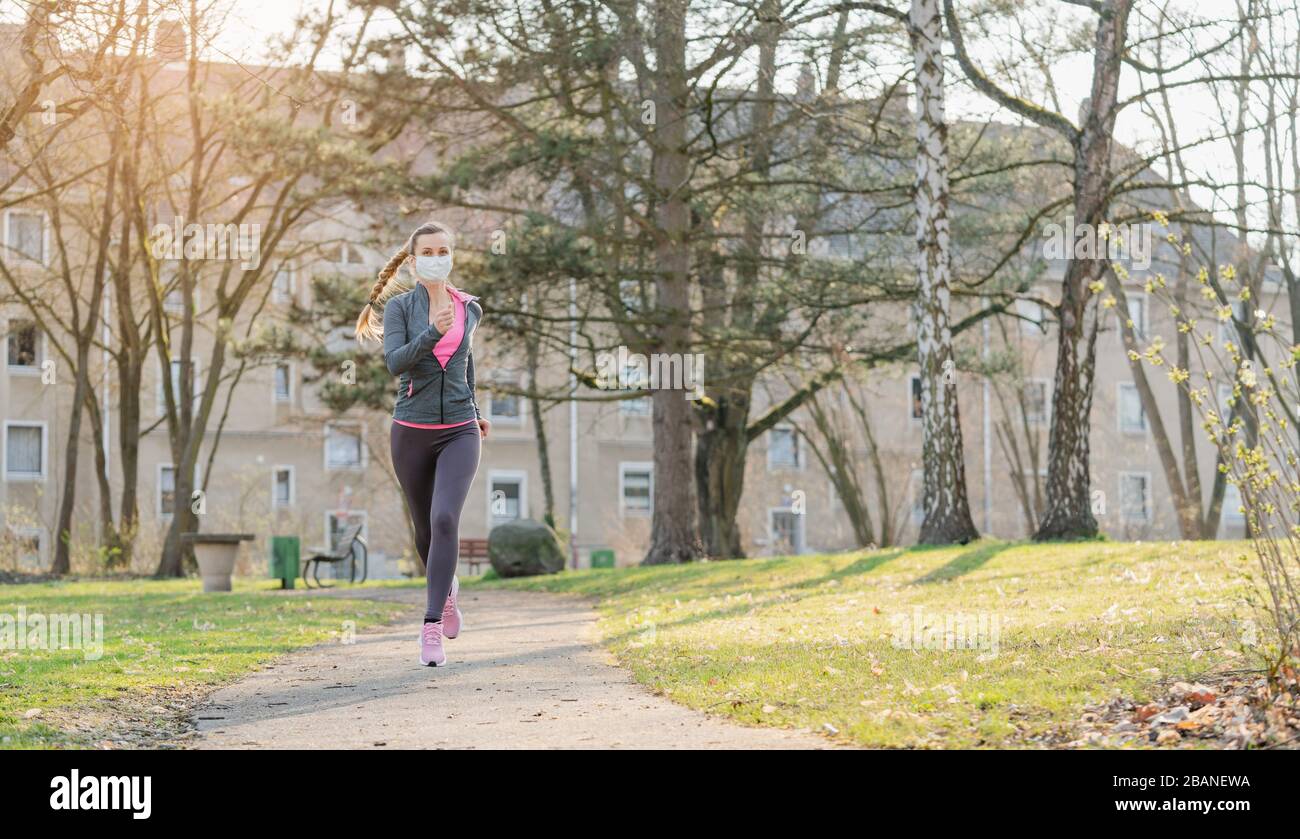 Woman jogging down a path boosting her immune system for covid-19 Stock Photo