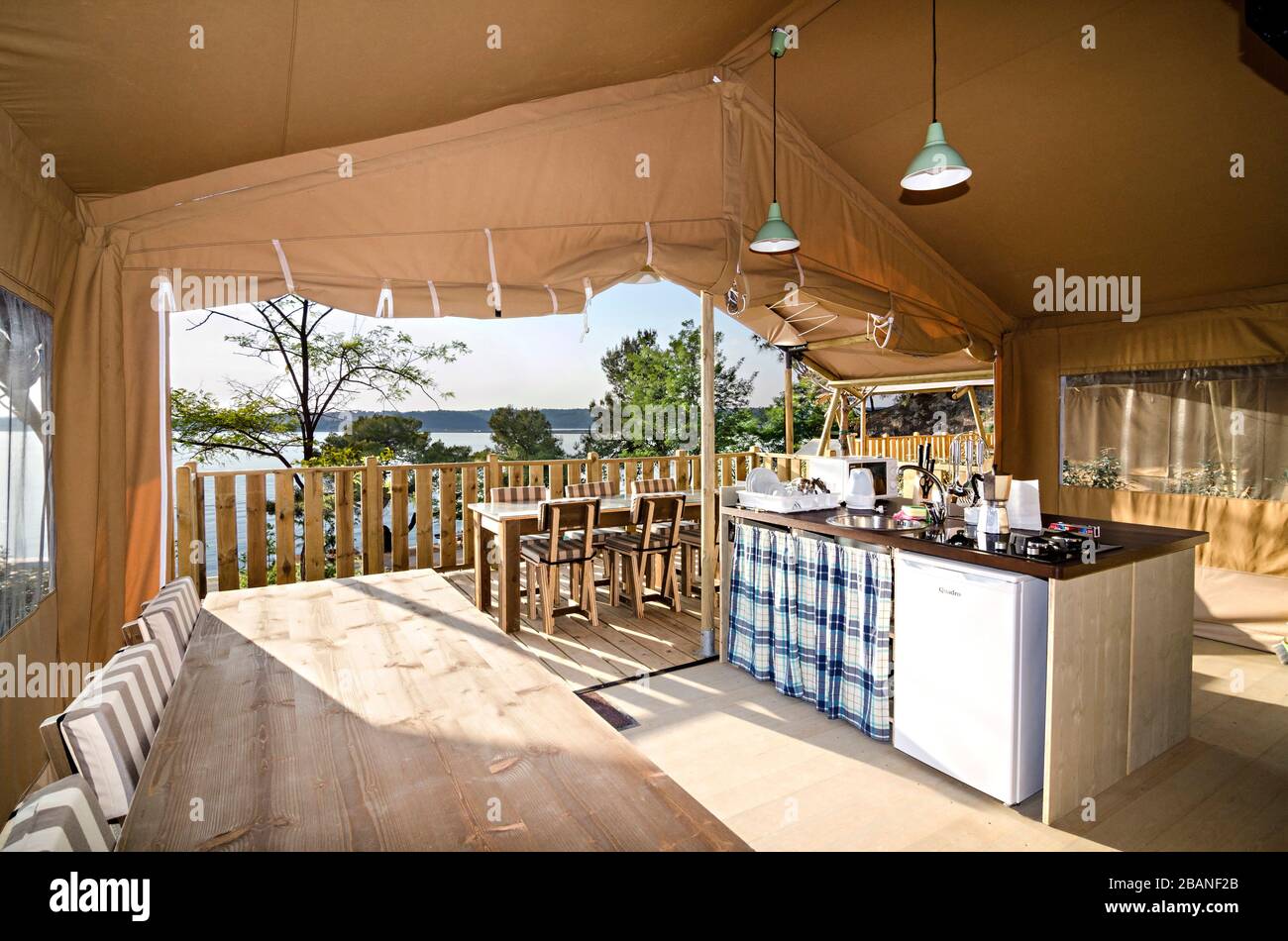 Terrace, kitchen and lounge of a glamping tent with sea view in a camping Stock Photo