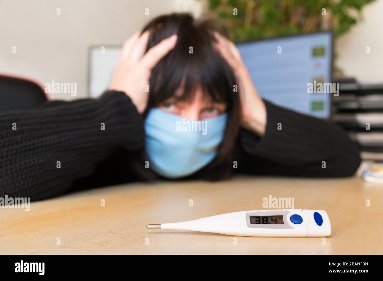 Covid-19 outbreak. Sick woman with headache and fever. Home quarantine. High temperature on medical thermometer. Fear of pandemic coronavirus disease. Stock Photo