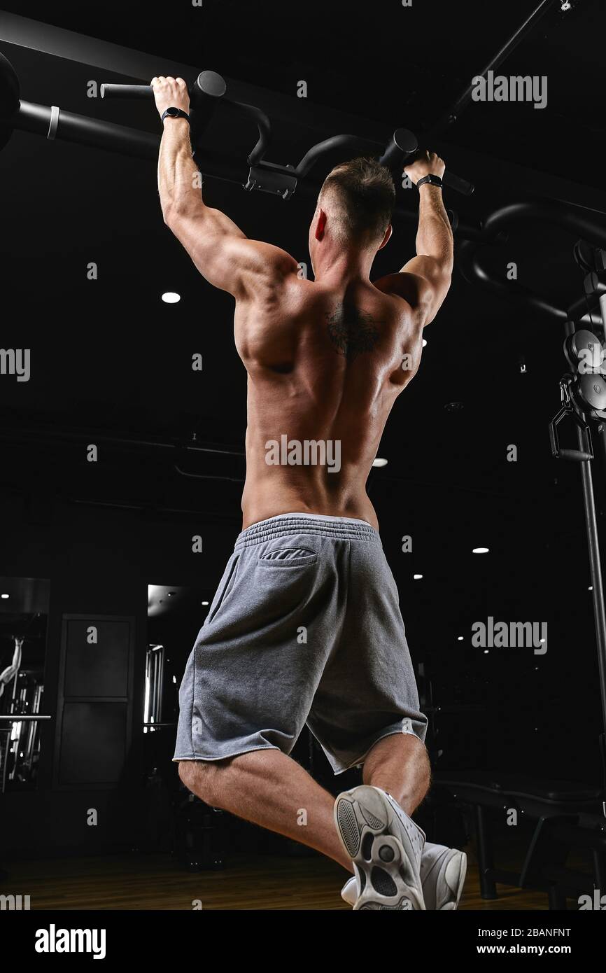 Strong man doing pull-ups on a bar in a gym Stock Photo - Alamy