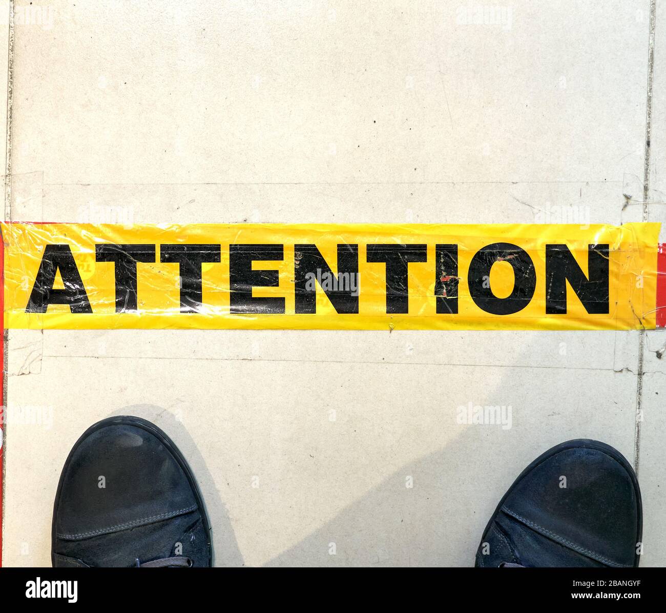 Attention line on floor in store to keep social distancing. Social distancing is deliberately increasing the physical space between people to avoid sp Stock Photo