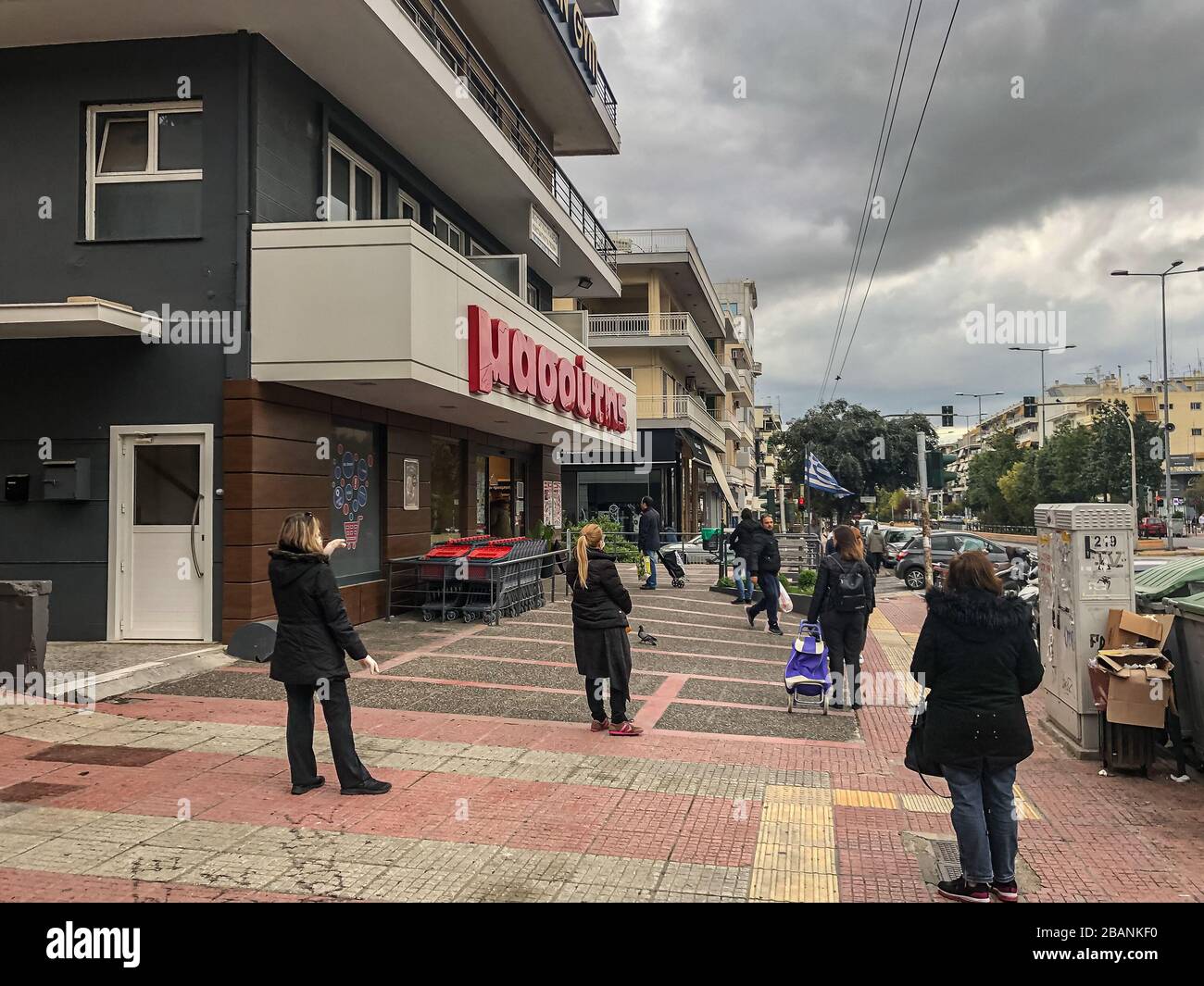 People waiting to enter to the Masoutis supermarket outside keeping safe distance. Athens, Greece. Stock Photo