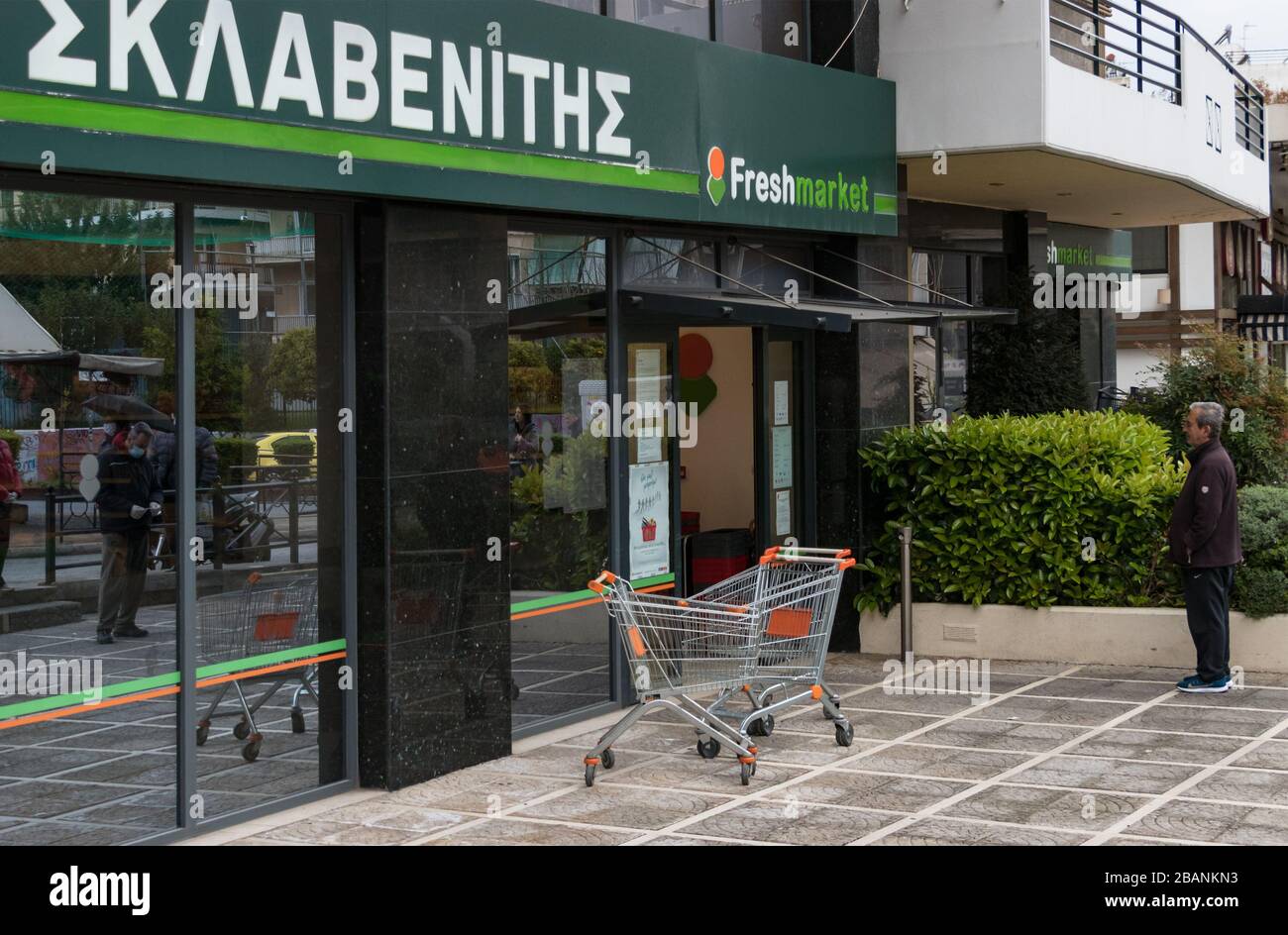 A customer waiting to enter to the Sklavenitis supermarket outside keeping safe distance. Athens, Greece. Stock Photo