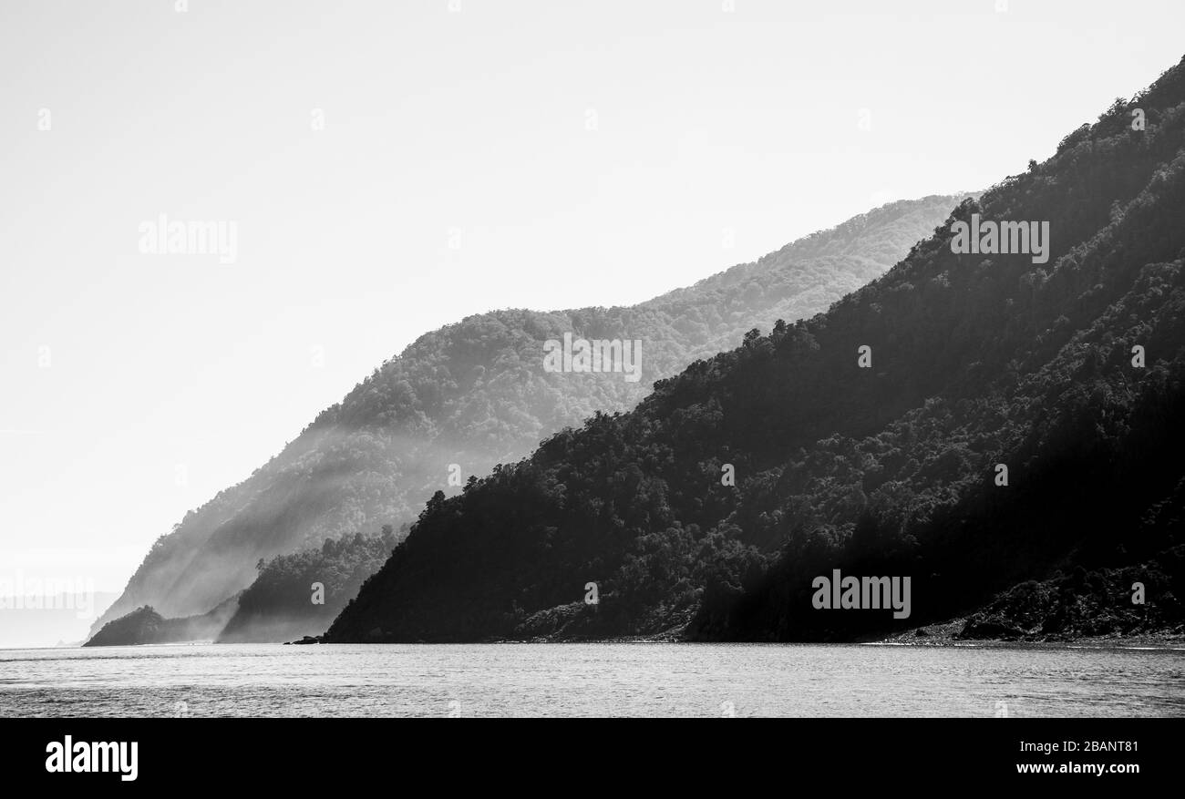 Milford Sound in the Southwest of New Zealand’s South Island. A fiord popular with tourists and travelers. Monochrome landscape of the fiord entrance. Stock Photo