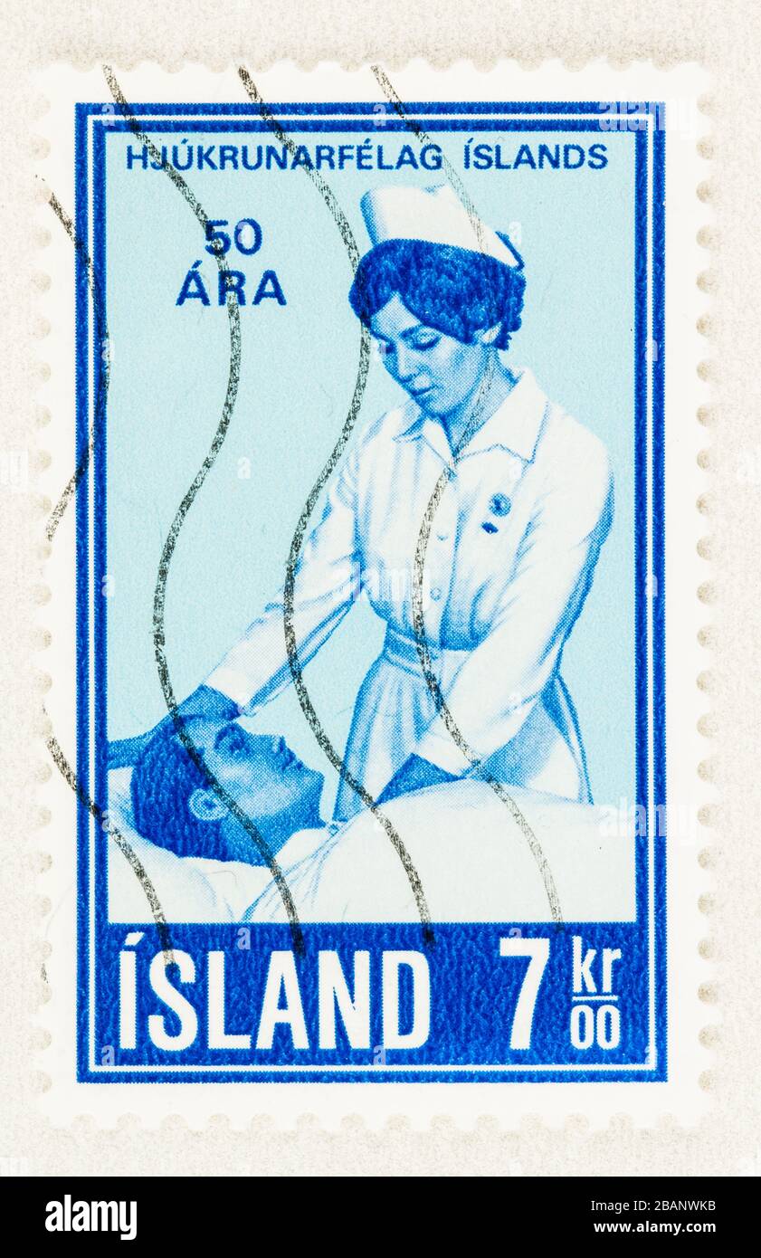 SEATTLE WASHINGTON - March 28, 2020: Close up of Iceland stamp featuring nurse with patient, commemorating 50th anniversary of Nursing Association. Sc Stock Photo