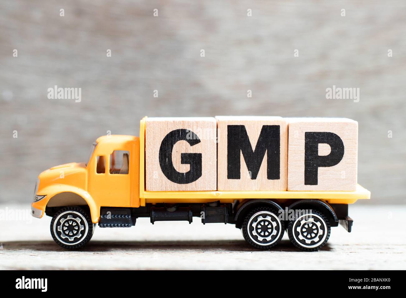 Truck hold letter block in word GMP (Abbreviation of good manufacturing practice) on wood background Stock Photo