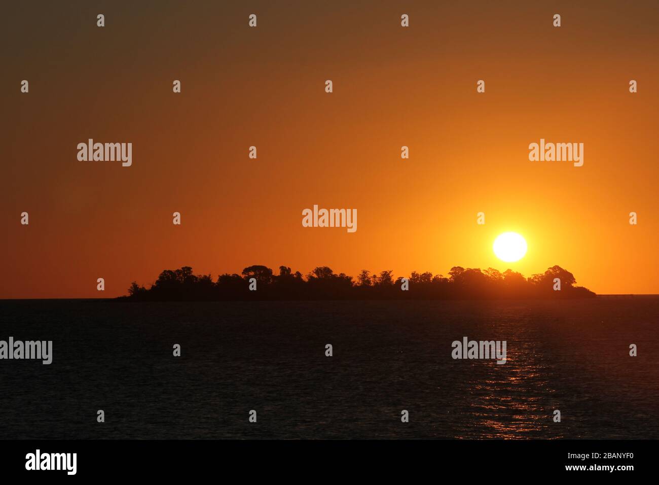 Sunset in Colonia del Sacramento, Uruguay. The sun hides behind Buenos Aires City Stock Photo