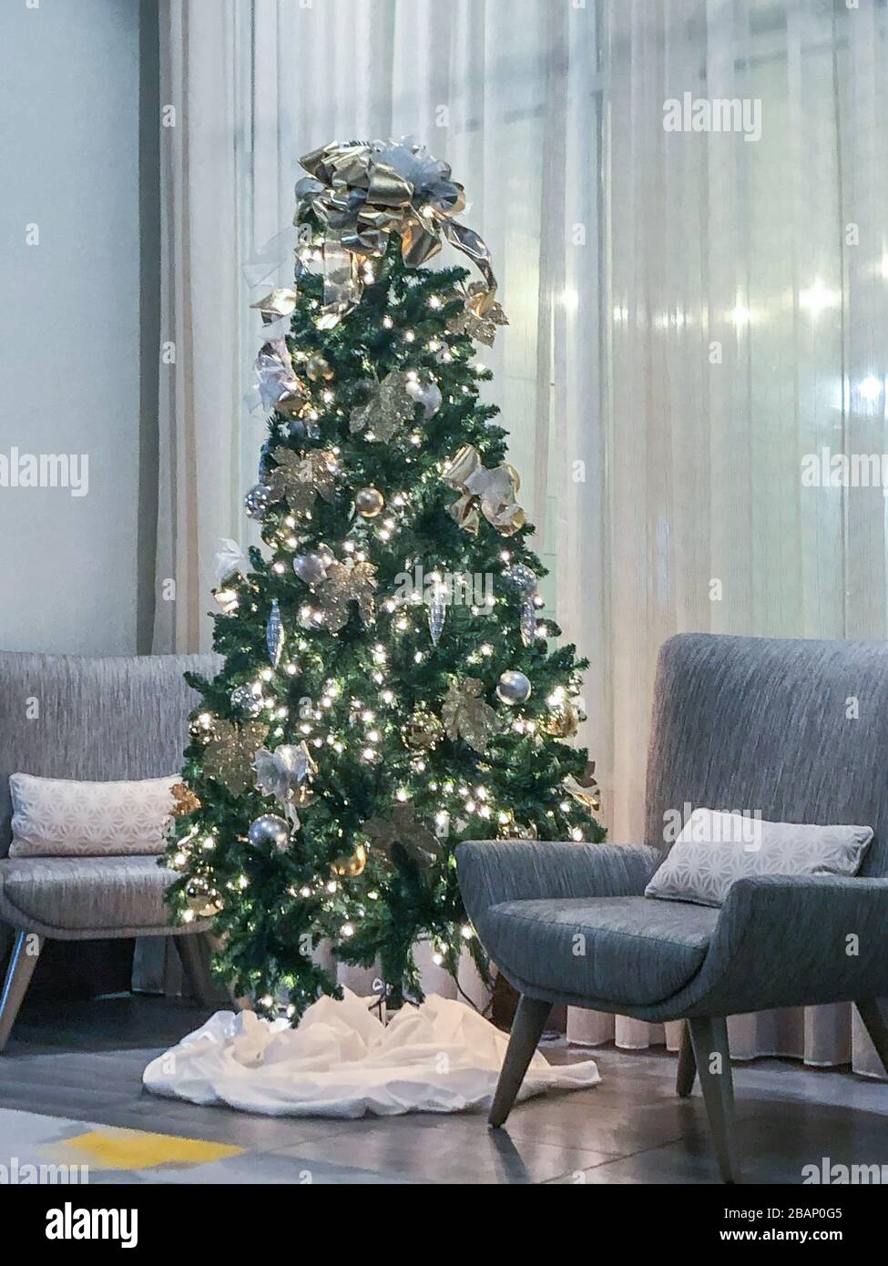 Interior shot of a Christmas tree surrounded by modern chairs in a business lobby area Stock Photo