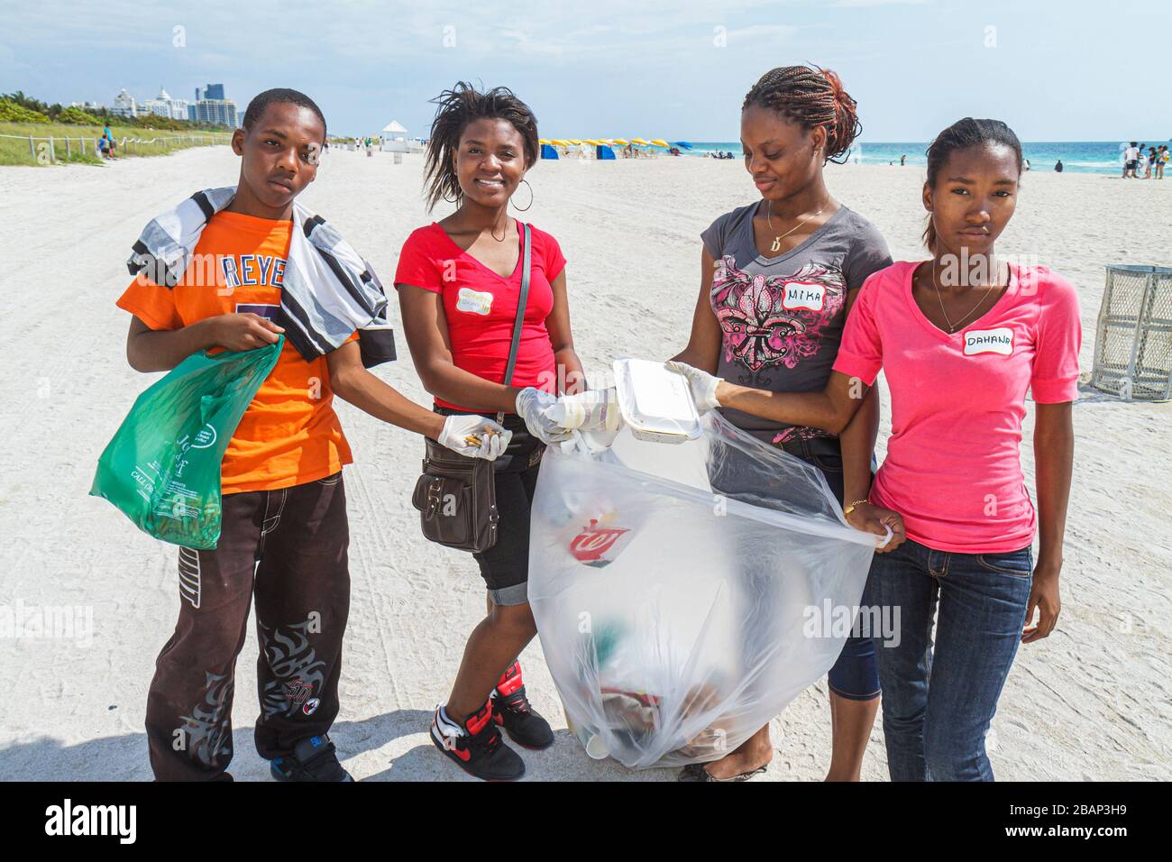 Miami Beach Florida,Hands On HandsOn,Miami Beach,Clean up,picking up collecting litter trash,volunteers working together serving students,Black boy gi Stock Photo