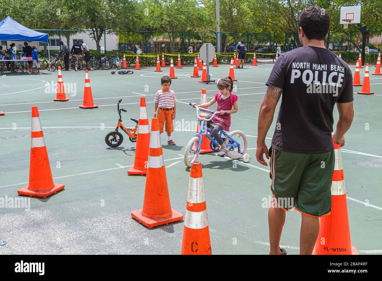 North Miami Beach Florida,Police Community Unit Bicycle Rodeo,riding obstacle course,orange traffic cones,girl girls,youngster,female kids children bo Stock Photo