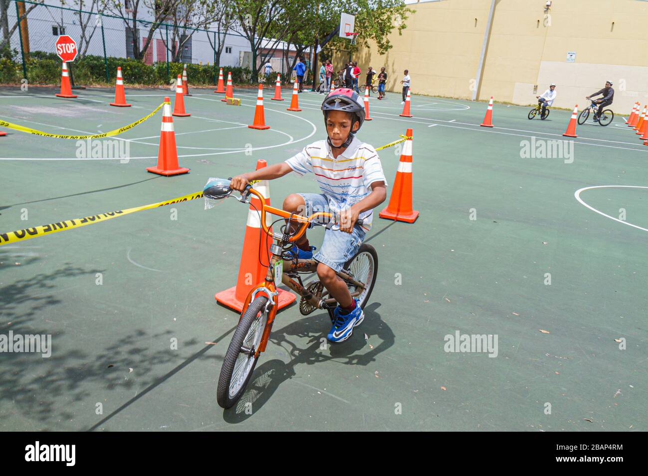 North Miami Beach Florida,Police Community Unit Bicycle Rodeo,riding obstacle course,orange traffic cones,Black boy boys,male kid kids child children Stock Photo