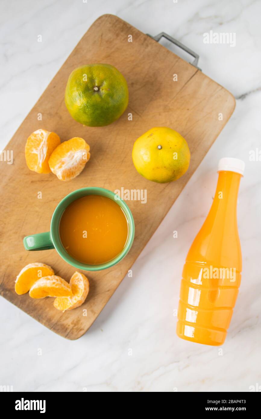 This is the picture of Orange Juice in a cup and in a bottle on marble. Stock Photo