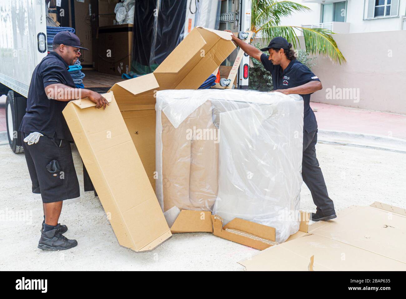 Miami Beach Florida,Macy's,driver,delivery,delivering,deliveryman,furniture,mover,recliner chair,Asian Black African Africans,man men male adult adult Stock Photo