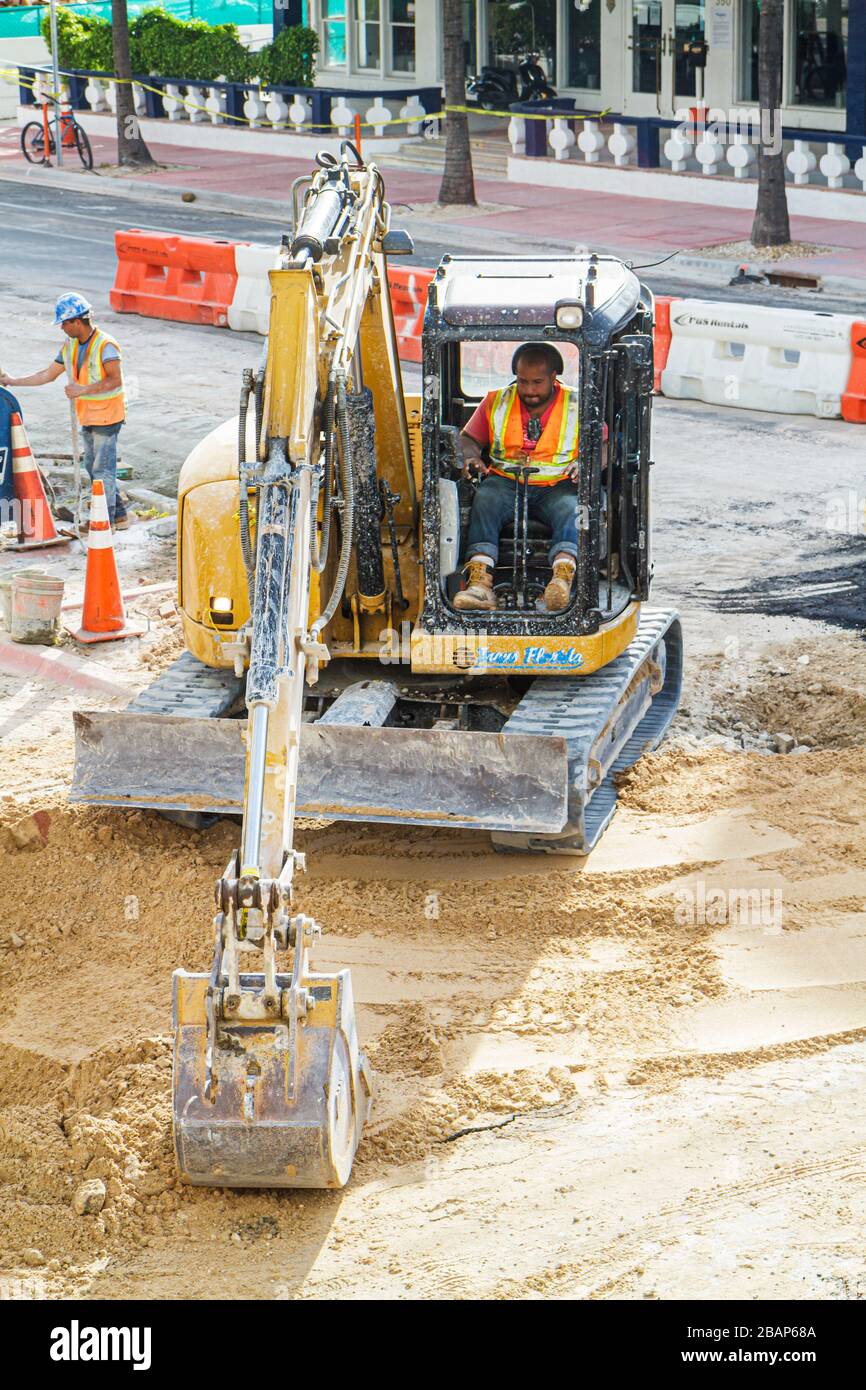 Miami Beach Florida,4th Fourth Street,sewer,road repair,under new construction site building builder,upgrade,tractor excavator,John Deere,operator,Bla Stock Photo