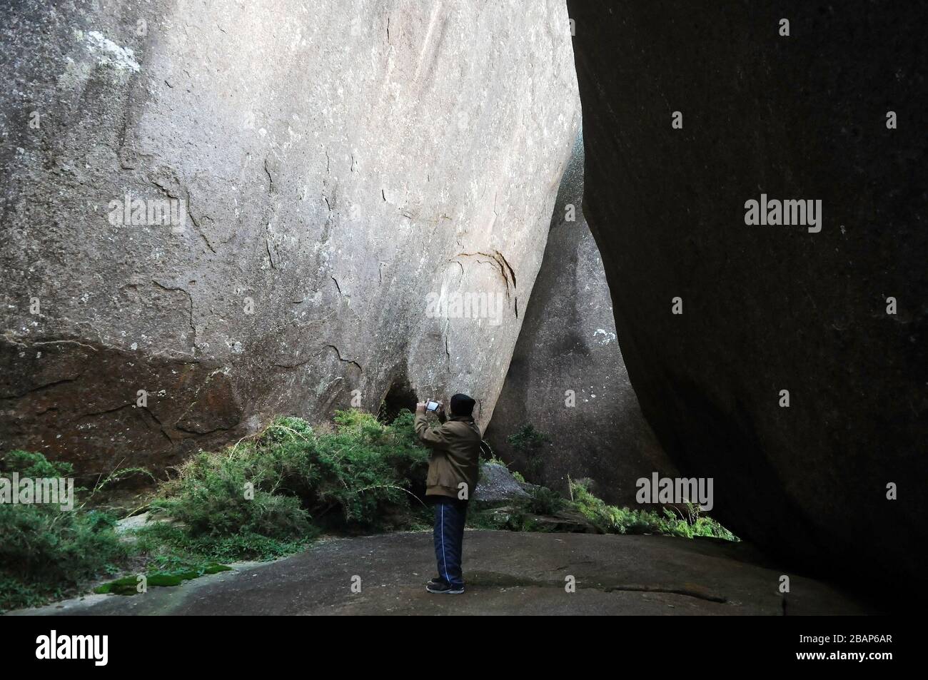 Petrópolis, Brazil, March 13, 2020. Man takes photos inside the crevices of Castelos do Açú in the Serra dos Órgãos National Park, in the most point o Stock Photo
