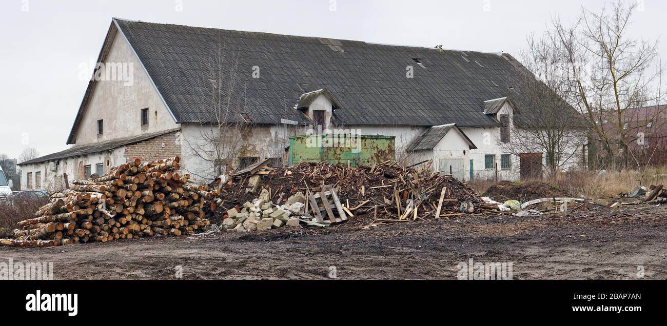 An illegal dump of garbage and wood waste was formed near a rustic old