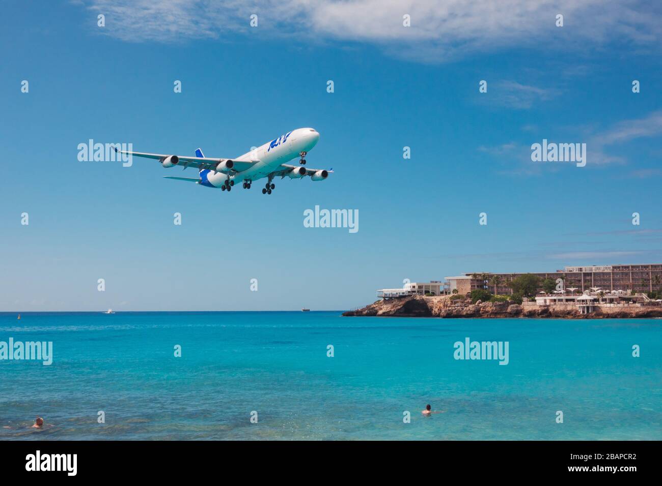 An Air France JOON Airbus A340-300 sails over tourists on Maho Beach, St. Maarten Stock Photo