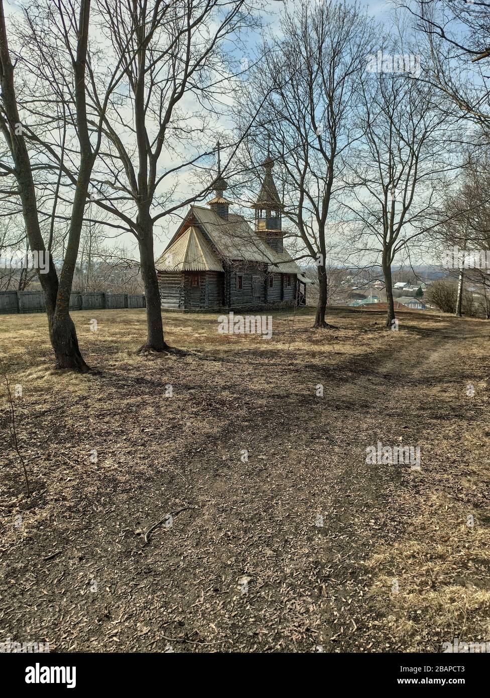 Ancient orthodox temple among trees. Landscape of central Russia. Windows, roof and doors are visible through branches. The village of Big Boldino Stock Photo