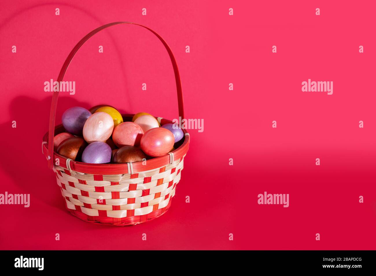 Easter painted eggs in basket isolated on red Stock Photo