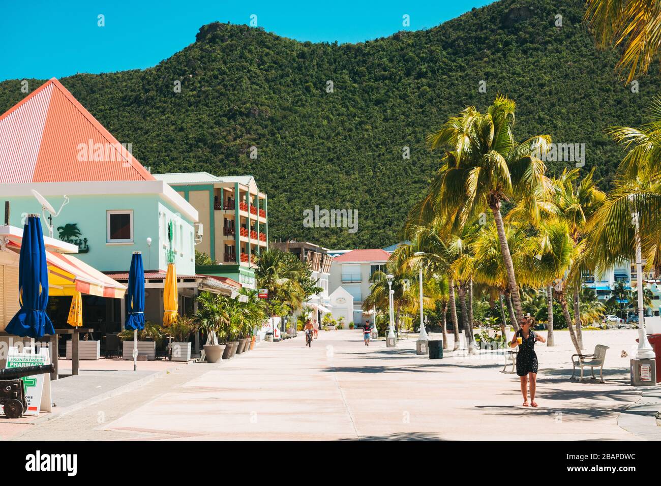 A tourist walks down a deserted promenade in Philipsburg, St. Maarten in late February 2020 Stock Photo