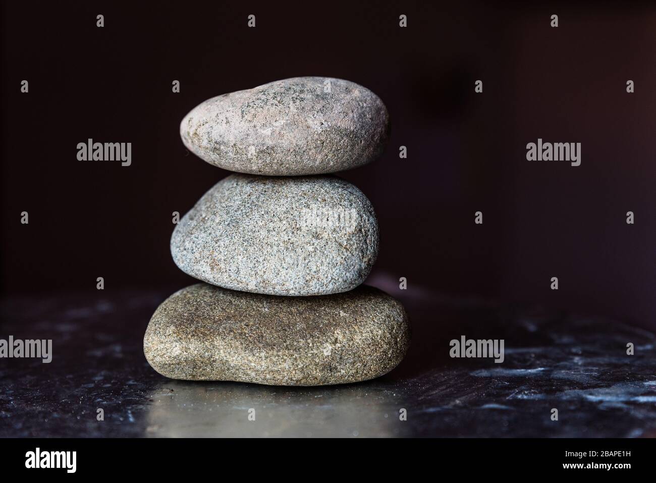 Three Stone Stack Stack of three Pebble Stones on dark background Stock Photo - Alamy