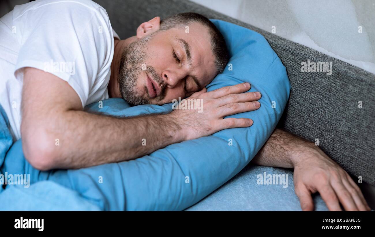 Mature Man Sleeping Hugging Pillow Lying In Bed At Home Stock Photo Alamy