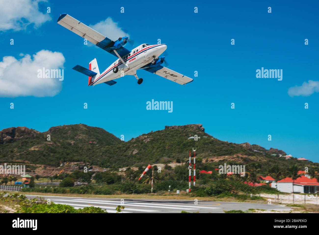 A Winair DHC6 Twin Otter departs over the beach at Saint Barthélemy Airport, French Caribbean Stock Photo