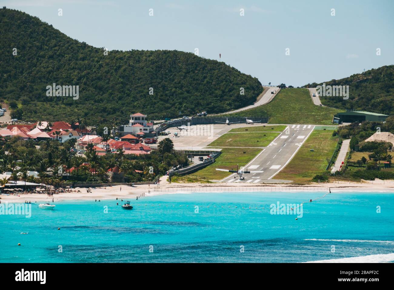 An aircraft makes an 'over the beach' runway 28 approach at Saint Barthélemy Airport, French Caribbean Stock Photo
