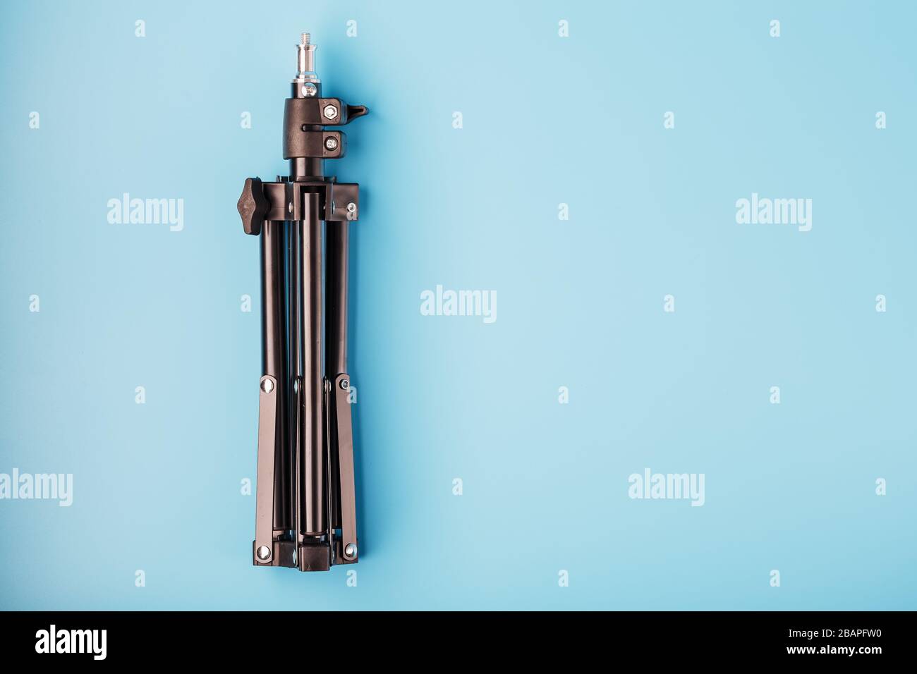 Tripod on a blue background for a photo-video camera and flash on a ...