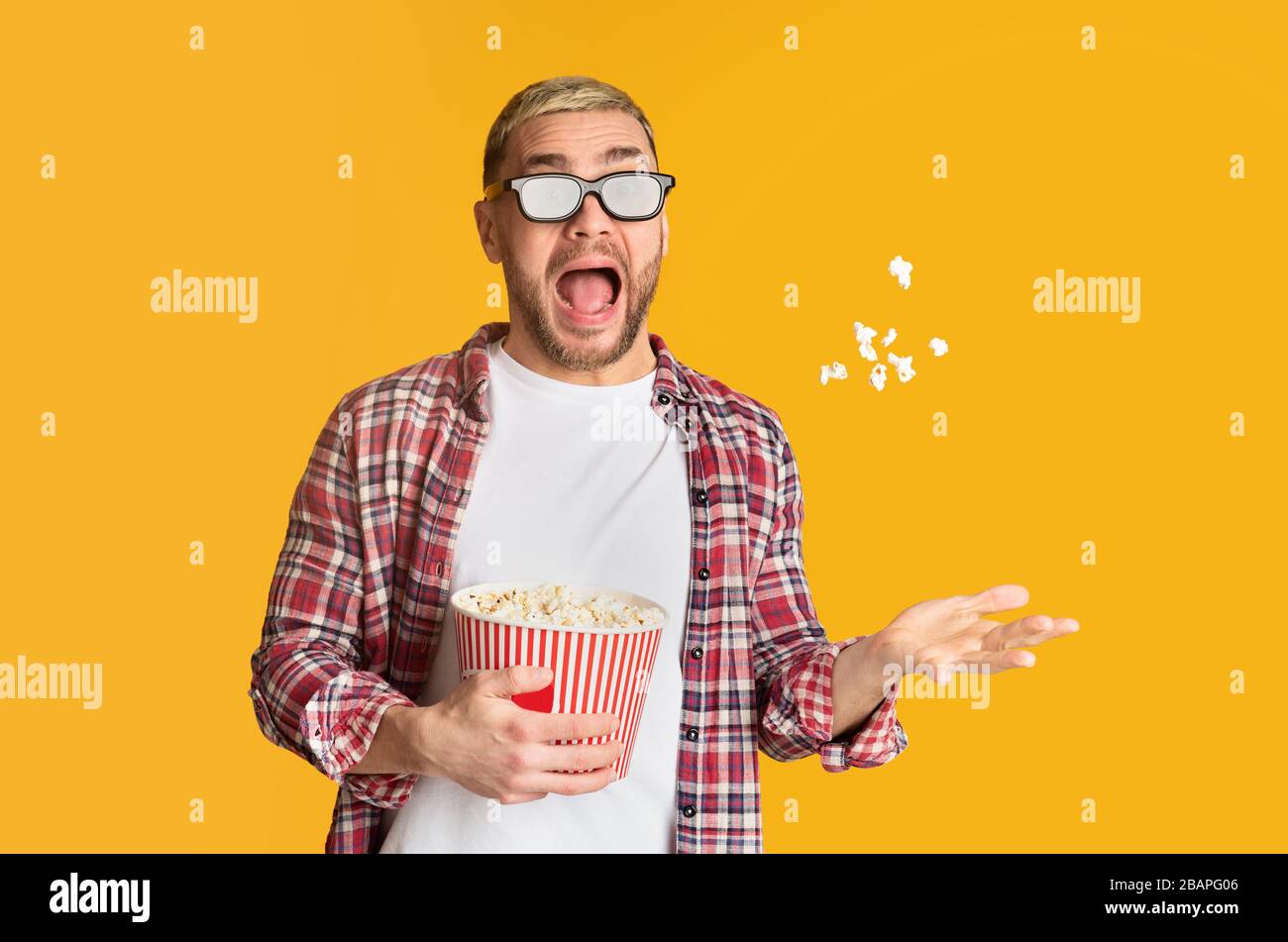 Scared guy in 3d glasses tossed popcorn Stock Photo