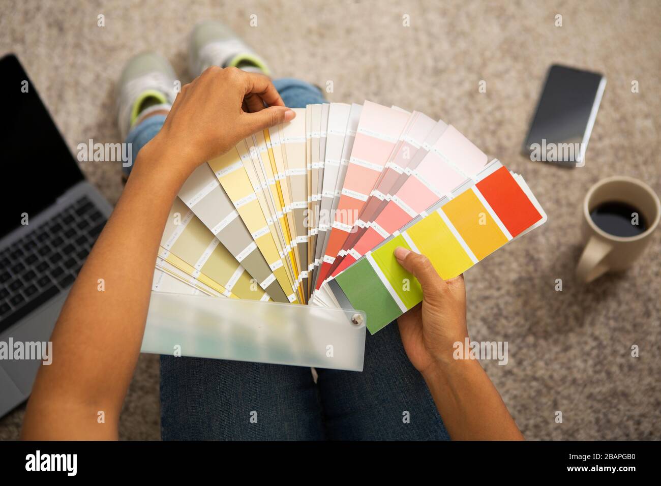 Girl chooses paint for interior from color swatch Stock Photo